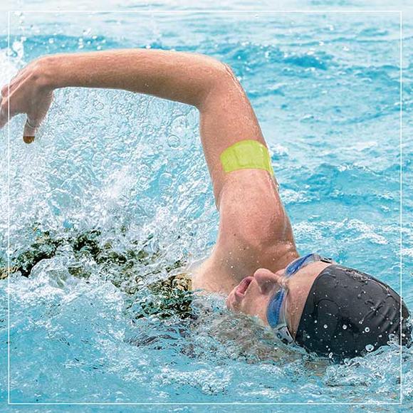 Man swimming with waterproof bandage on arm